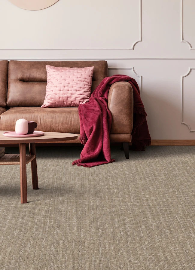 brown carpet in a modern living room with a brown leather couch and pink accents